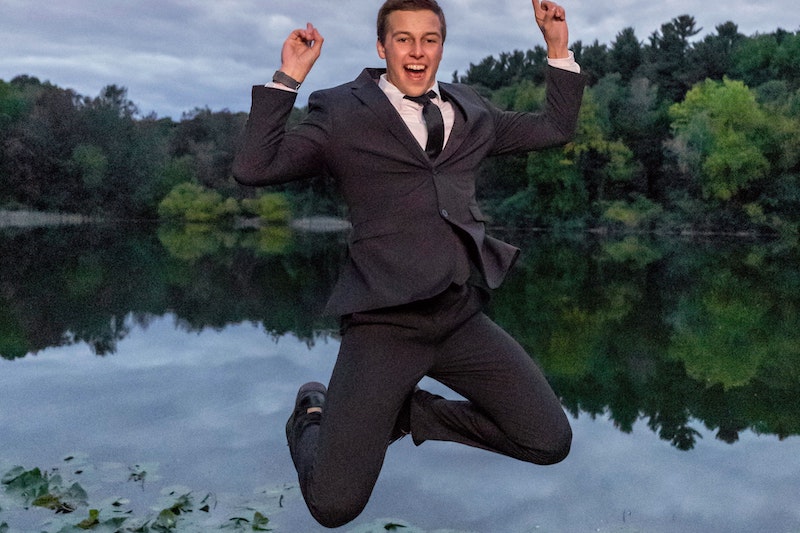 Businessman jumping in a lake