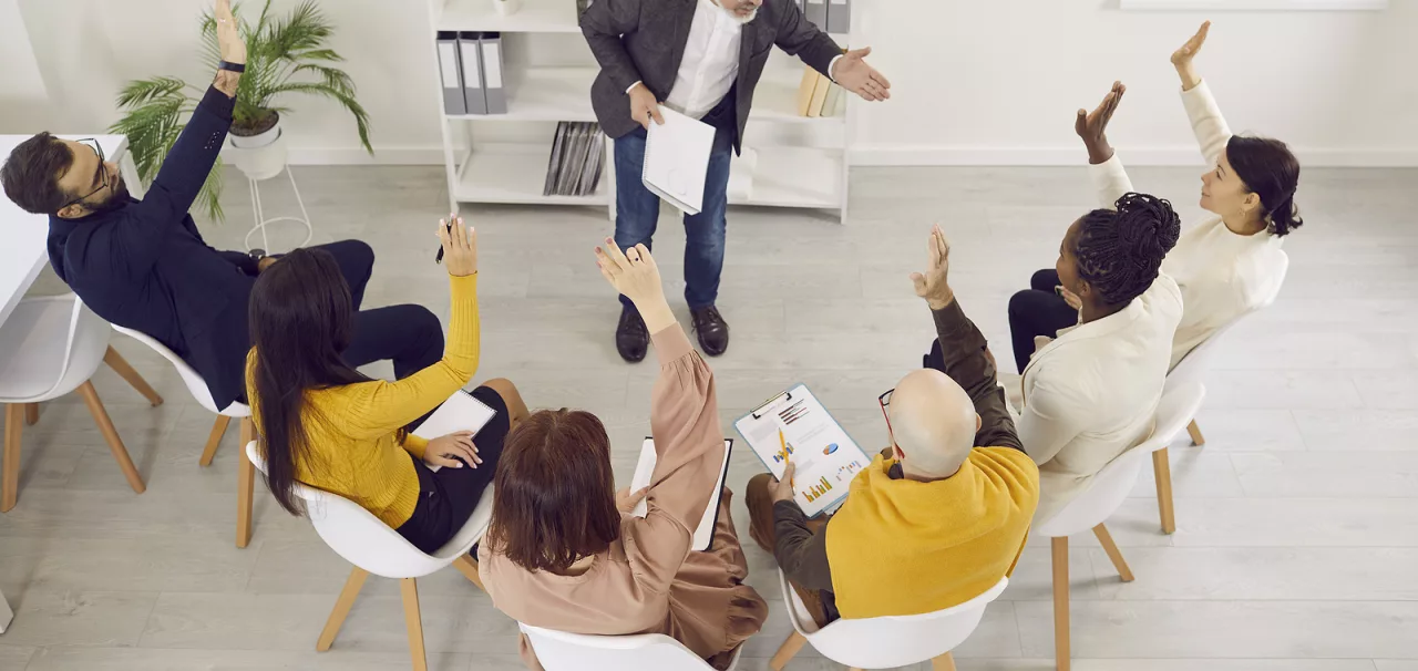 People raising their hands during a meeting