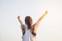 Woman raising both hands in success