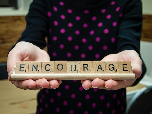 A person holding the word "courage"