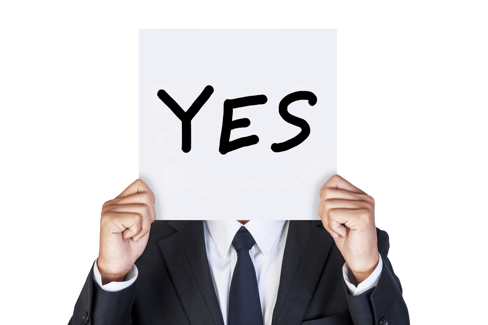 A person raising a "YES" card