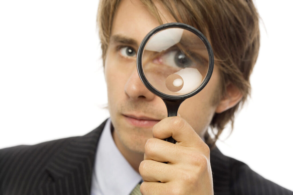 A man looking through a magnifying glass